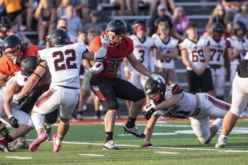 Palmyra’s Nolan Richards (39) spins out of the arms of Hannibal’s `Brady Zimmerman (11) during the Hannibal Jamboree Friday at Porter Stadium.  Mathew Kirby/Courier Post
