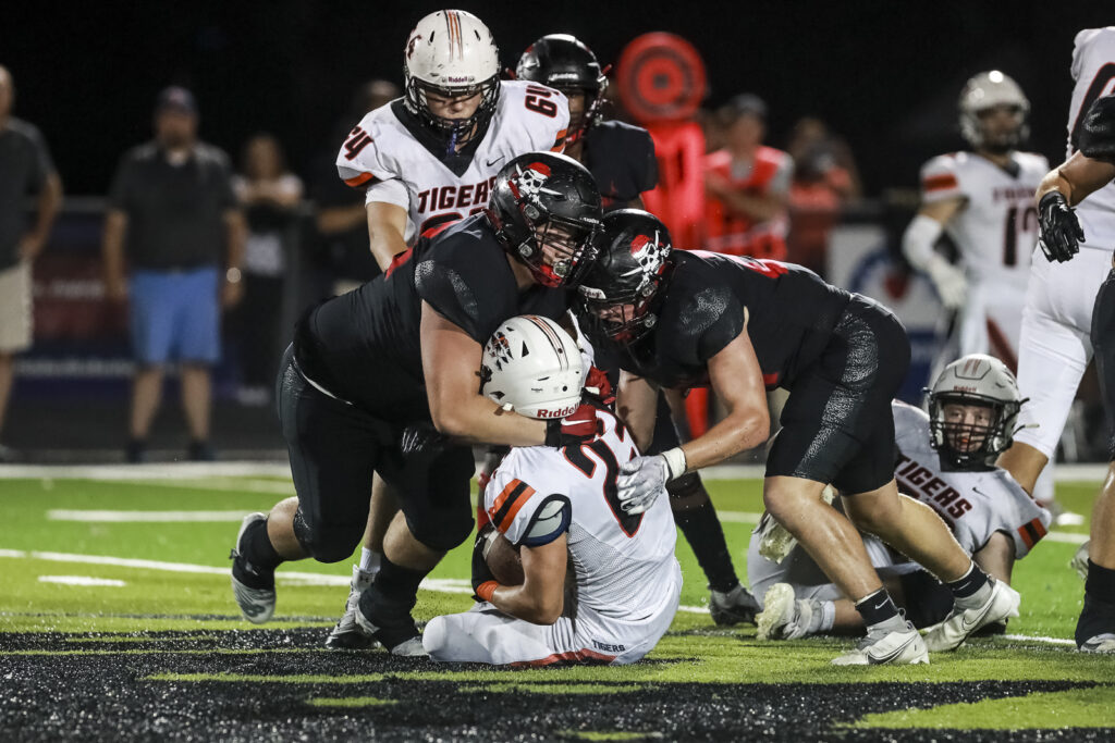Hannibal’s Trenton Cowden (left) and Kane Wilson (right) tackle Kirksville’s Landon Yardley (23) for a loss during the Pirates game against the Tigers Friday in Hannibal.  Mathew Kirby/Herald Whig-Courier Post