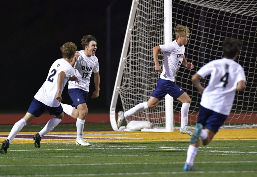 Quincy Notre Dame teammates celebrate a goal by Tanner Anderson (center) on a penalty kick. Quincy Notre Dame defeated Althoff 4-1 in the championship game of the Class 1A state soccer tournament at the East Side Centre in East Peoria, IL on Saturday October 29, 2022.  
Photo Courtesy Tim Vizer Photography