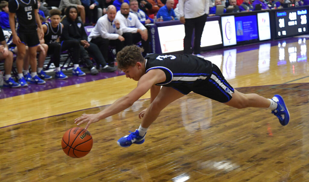 Quincy guard Ralph Wires chases a loose ball headed out of bounds during Friday’s championship game with Decatur MacArthur in the Collinsville Prairie Farms Holiday Classic at Vergil Fletcher Gym in Collinsville, Ill.