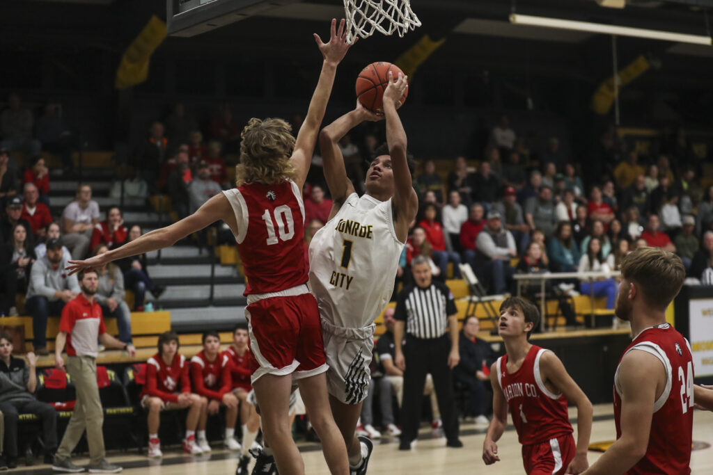 Monroe City’s Jaylyn Countryman (1) shoots over Marion County’s Caden Scotts (10) during the Panthers game against Mustangs in the opening round of the 98th Annual Monroe City basketball tournament.  Mathew Kirby/herald Whig-Courier Post