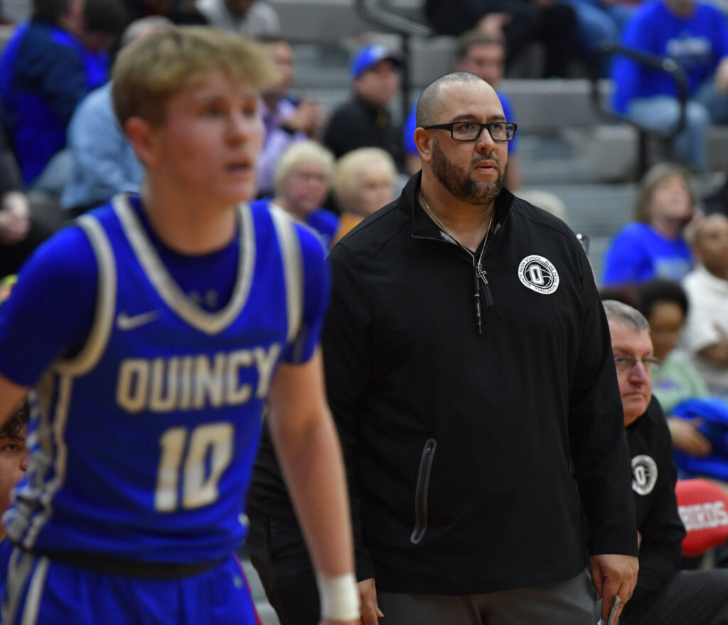 Quincy head coach Andy Douglas watches late in the game. At left is Quincy guard Tyler Sprick. Quincy lost to OFallon in a semifinal game of the Moline Class 4A sectional which was played at Alton High School in Alton, IL on February 28, 2023. 
Photo Courtesy Tim Vizer Photography