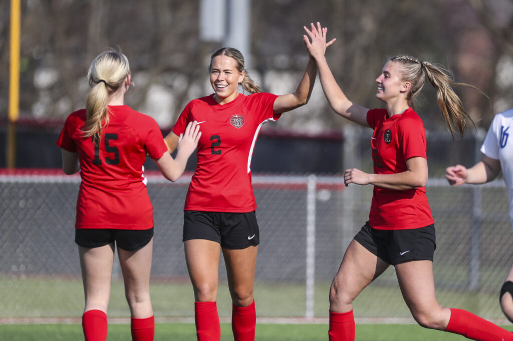 Hannibal’s Malia Stolte )(2) celebrate after scoring a goal with Macy Behrens (15) and Aly Falconer (18) during the Pirates conference showdown against the Moberly Spartans, Thursday in Hannibal.  Mathew Kirby (Herald WhigCourier Post)